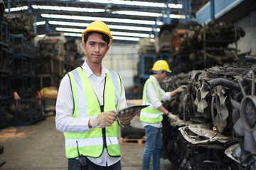 Worker or Engineer work in factory and using tablet for check stock and inspection in machine spare part engine warehouse