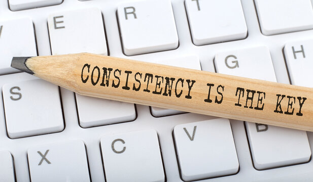 CONSISTENCY IS THE KEY text on pencil on the keyboard background