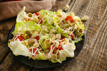 Tasty popcorn salad in lettuce wraps on wooden background
