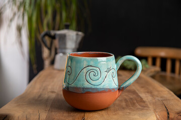 cup of coffee with mocha pot on a wooden table