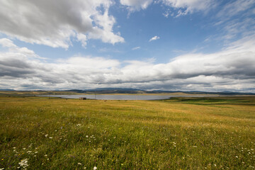 Obraz premium Landscape and view of lake in Tsalka, Georgia. Green field and clouds.
