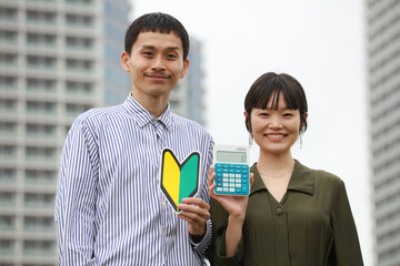 電卓と初心者マークを持つ夫婦