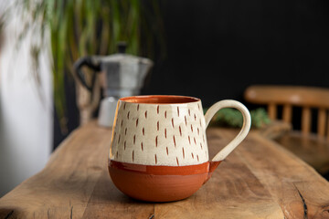 cup of coffee with mocha pot on a wooden table