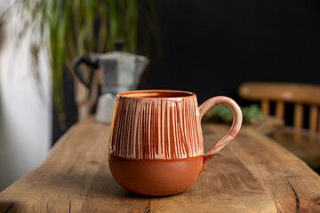 cup of coffee with mocha pot on a wooden table
