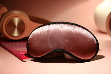 Stylish sleeping mask on color background, closeup