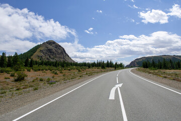 mountains against the background of clouds and the road stretching into the distance