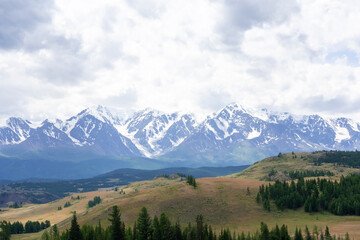 snowy peaks of mountains and steppe on a background of cloudy sky