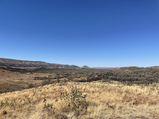 The stunning MacDonnell Ranges, outside Alice Springs, Northern Territory, Australia.  With long roads and open plains with distant mountains.