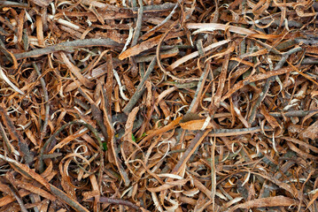 Waste wood at the factory. Thistle texture. Remains of wood after processing boards in a furniture factory.