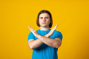 No way, absolutely not! Portrait of determined man in blue t-shirt showing x sign with crossed...