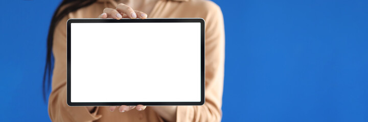 Woman holding digital tablet with white screen in her hands closeup