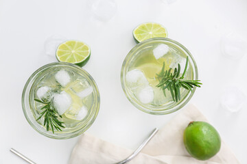 Glasses of tasty lime lemonade with rosemary on light background, closeup