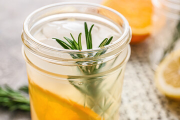 Glass of tasty orange cocktail with rosemary, closeup