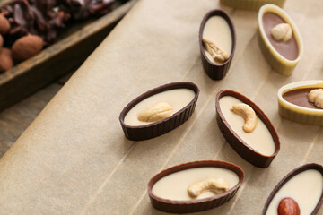 Tasty chocolate candies on baking parchment, closeup