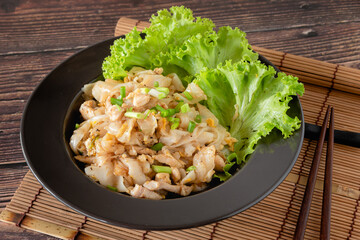 Stir-fried noodles with chicken as street food, Chinese food for launch on wooden background