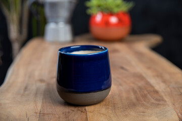 cup of coffee with mocha pot on a wooden table