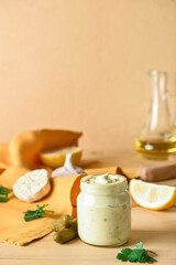 Glass jar with tasty tartare sauce and ingredients on color background