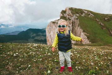 Fototapeta na wymiar Baby traveling in mountains family vacation hiking tour active healthy lifestyle 2 years old child girl outdoor