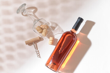 Bottle of exquisite wine, glass and corkscrew on light background
