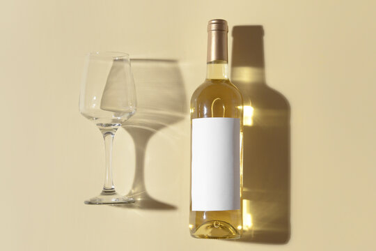 Bottle of exquisite wine and glass on color background