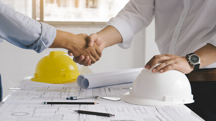 Business man and construction engineer shaking hands after finish an agreement in the home office,...