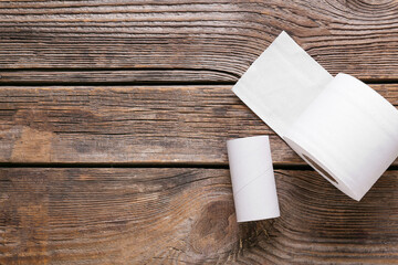 Roll of toilet paper and cardboard tube on wooden background