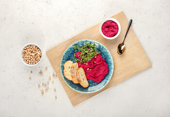 Composition with tasty beet hummus, bread and chickpeas on light background