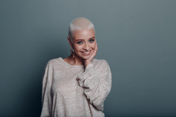 Millenial young woman with short blonde hair smiling portrait with hands touching face skin