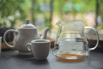 Drip coffee in a glass pitcher and white ceramic coffee mug.