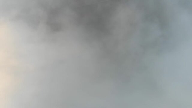 Aerial view of thick clouds over the old city, cinematic view from an aircraft