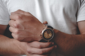 Mechanical men's watches on the hands of a guy. Guy puts a watch on his hand, close-up