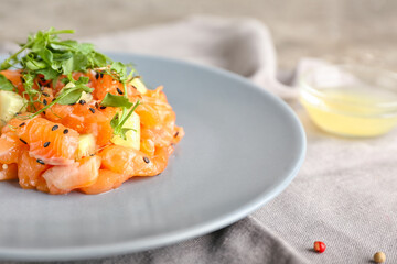 Delicious salmon tartar on grunge background, closeup