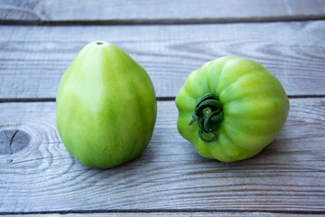 Tomatoes close-up. Two tomatoes lie on a wooden background.