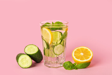 Glass with cucumber lemonade on color background
