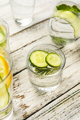 Glasses with cucumber lemonade on light wooden background
