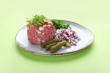 Plate with tasty beef tartare on color background