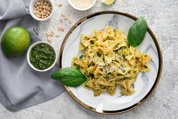 Plate with tasty pesto pasta on grunge background