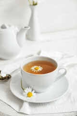Cup of floral tea on light background