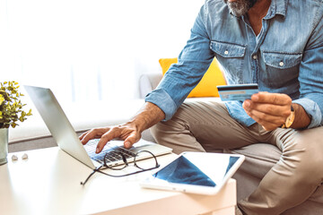 Men entering credit card information using laptop computer keyboard. Online shopping concept. Man...