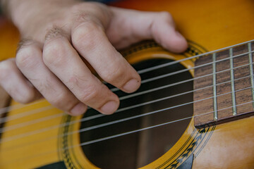 Fototapeta premium close-up of a guitar playing with a man's hand playing the strings