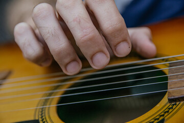 Fototapeta premium close-up of a guitar playing with a man's hand playing the strings