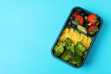 Lunch box with tasty food on blue background