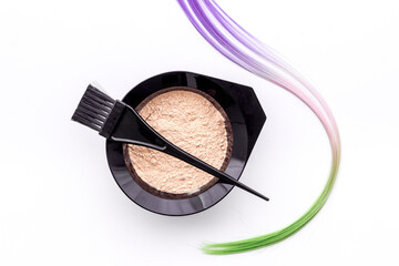 Mixing hair dye in bowl with brush and strand of hair