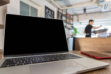 Modern laptop for online business working freely outside home on table near counter of beverage cafe along with atmosphere of drinking, eating, relaxing, comfortably build up creativity