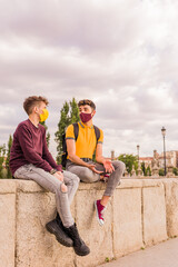 Young latin man and hispanic transgender friends during the new normal social distance. face mask
