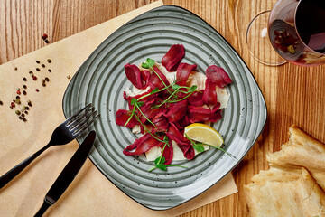 Sliced spicy air-dried basturma with flatbread and red wine