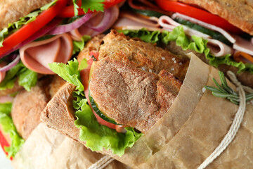 Tasty ciabatta sandwiches in craft paper, close up