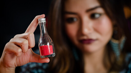 Asian witch examining magic ingredients