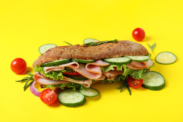 Ciabatta sandwich and ingredients on yellow background