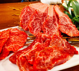 Close-up sliced wagyu marbled beef on plate.